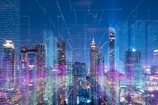 Aerial view of city sky scrappers at night overlaid with graphics of digital binary codes
