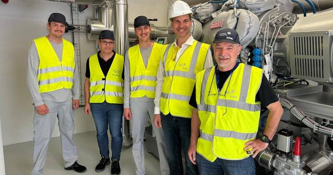 Five workers in uniform standing for the photograph in the facility