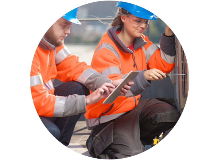 Two construction workers with one looking at the tab while other one fixing with the machine