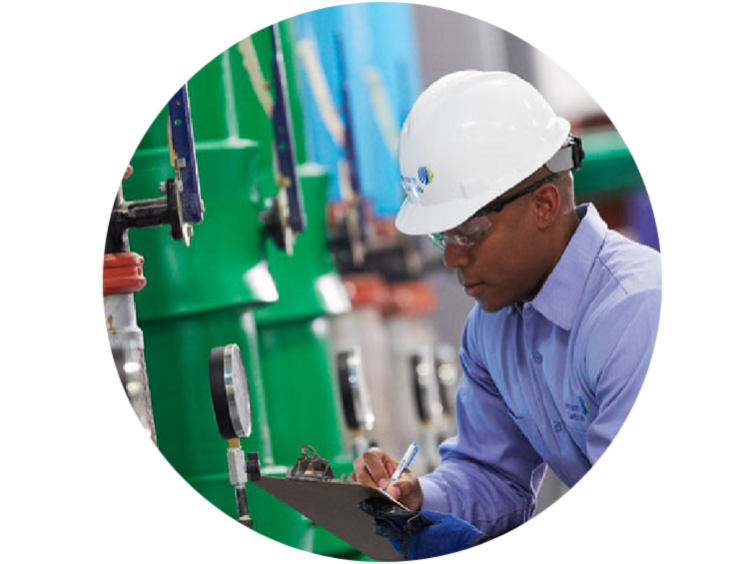 An engineer taking down the readings from machine and writing on the note pad