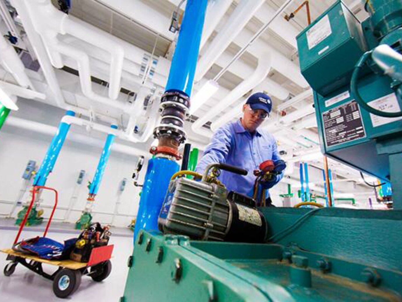 A man operates a machine, focused on his task in a workshop environment
