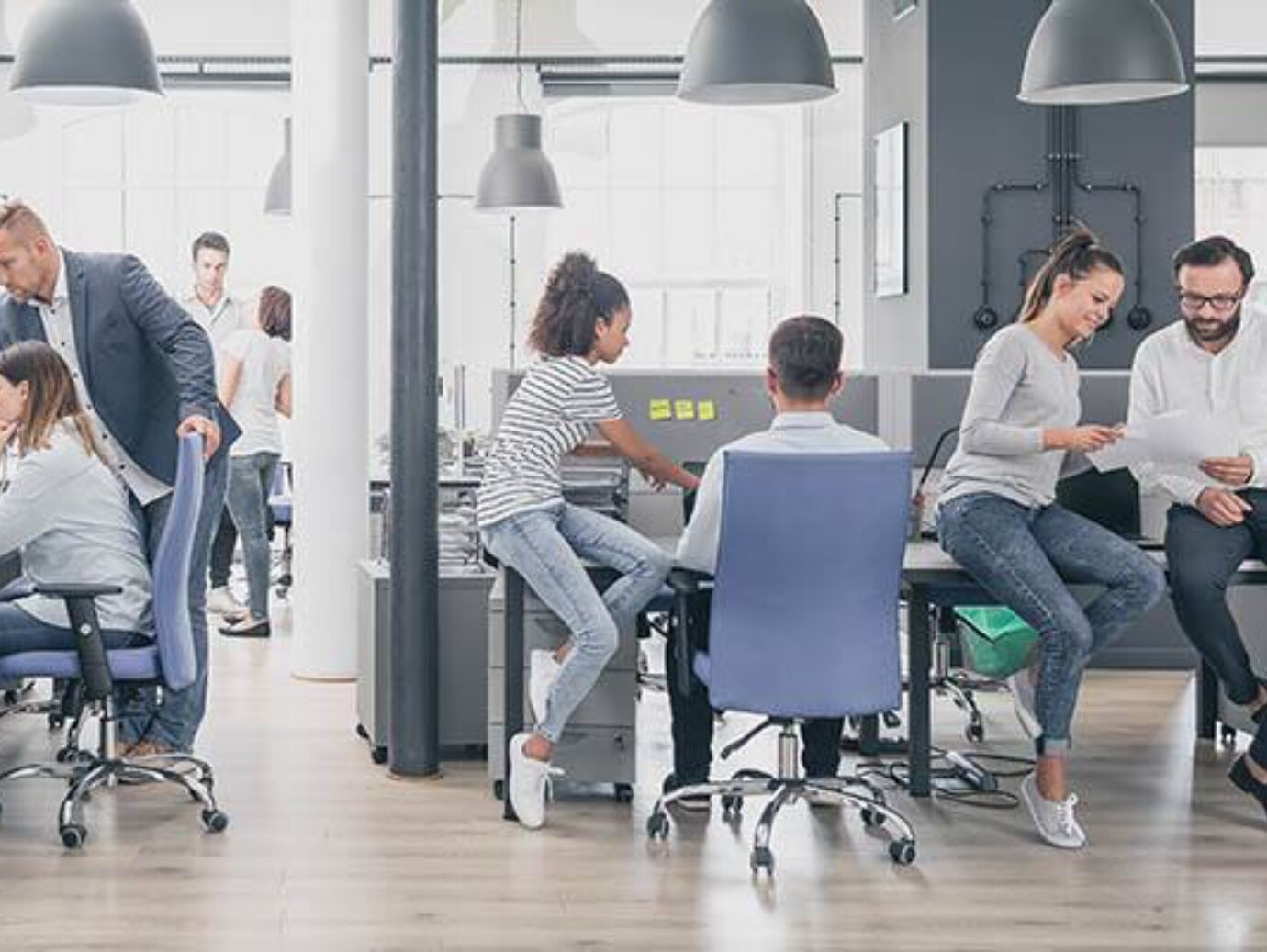 A professional workspace where people are actively working at desks