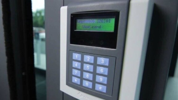 A keypad on a door featuring a green light, signaling that the door is unlocked or accessible