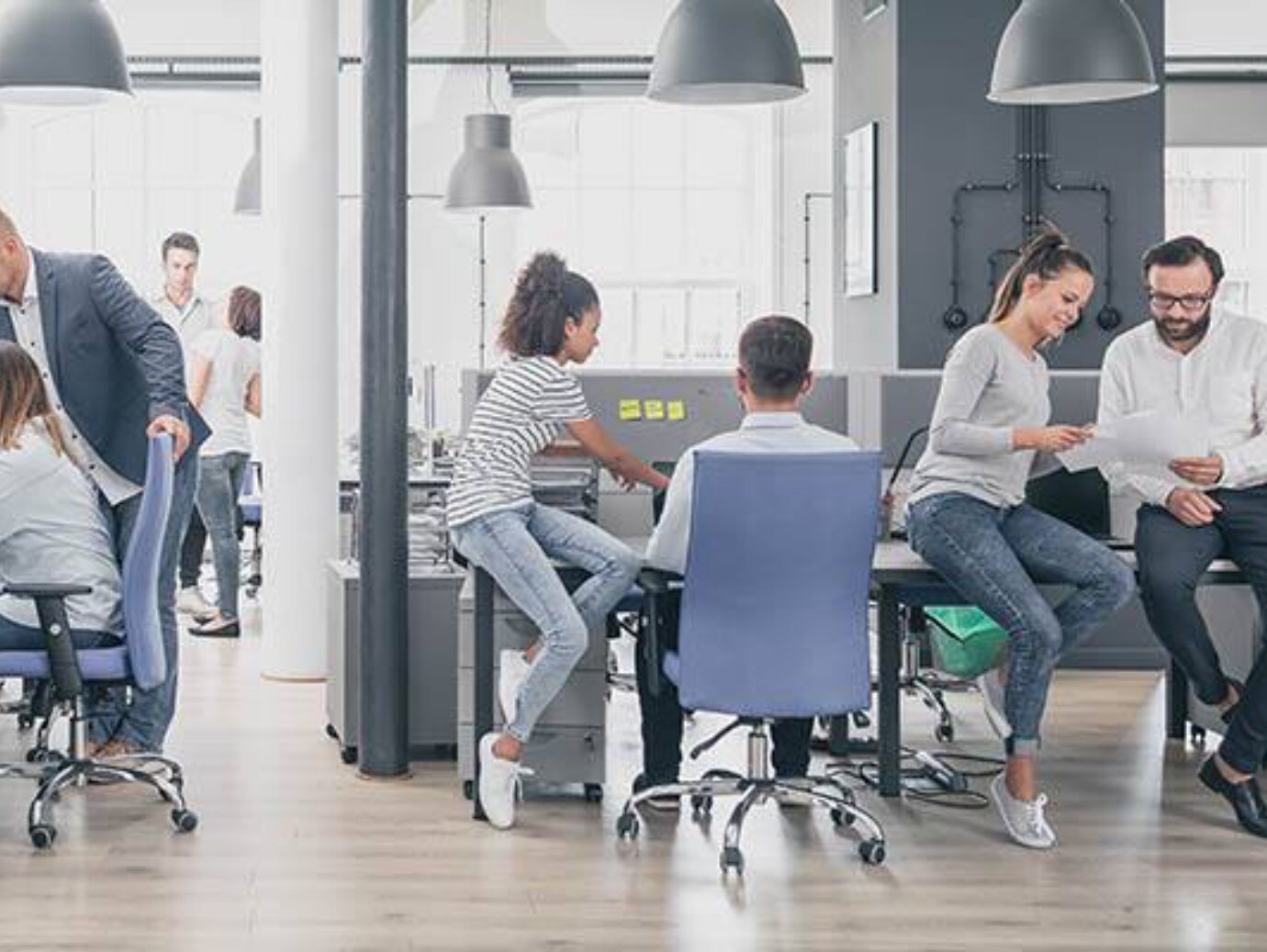 A professional workspace where people are actively working at desks