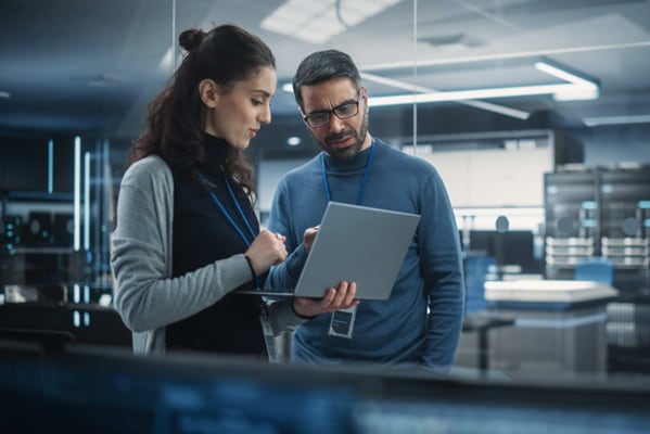 Two employess looking into laptop