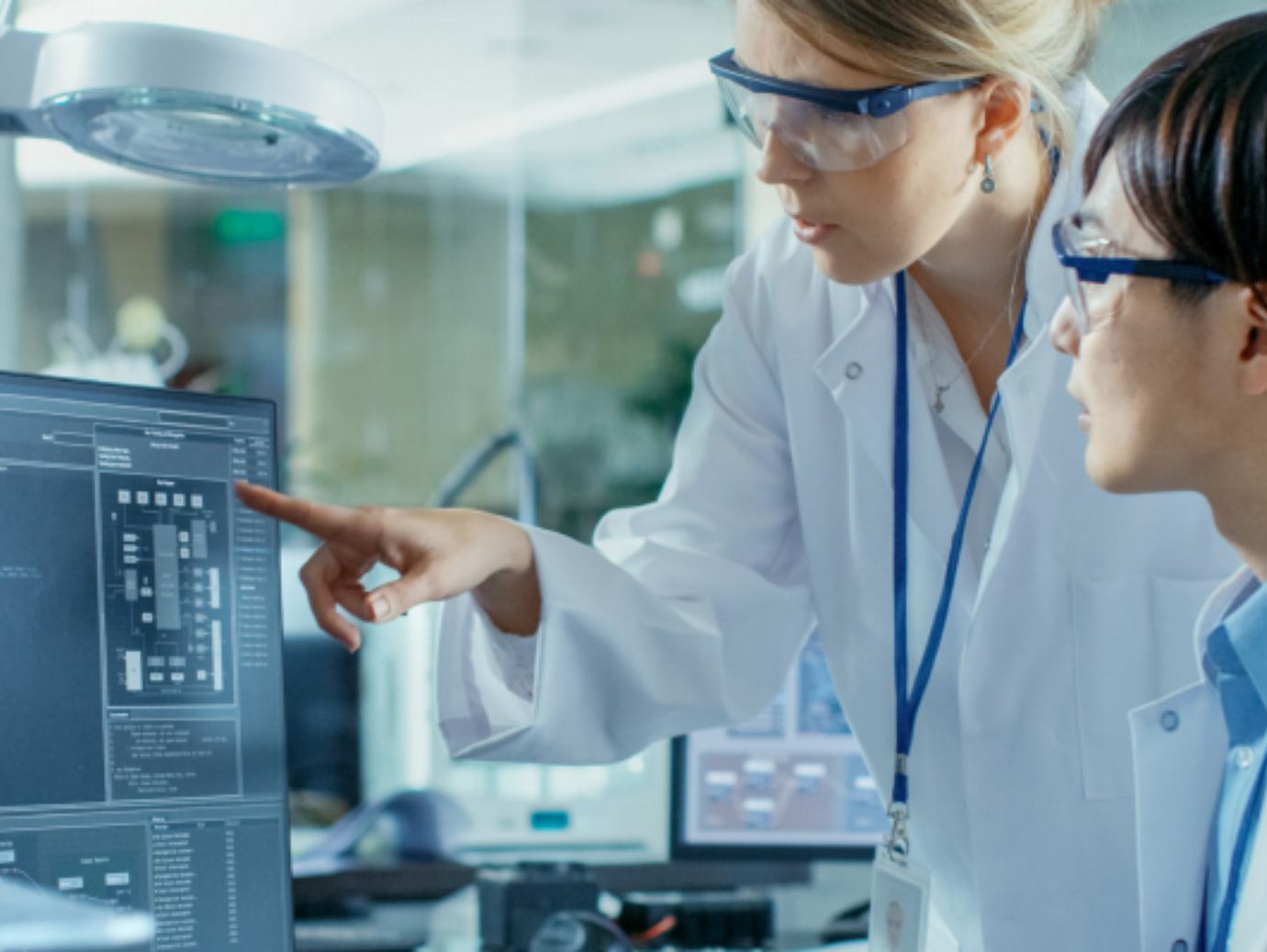 Two scientist at work discussing while looking the at the monitor