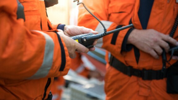 Close up of a worker holding a walkie talkie