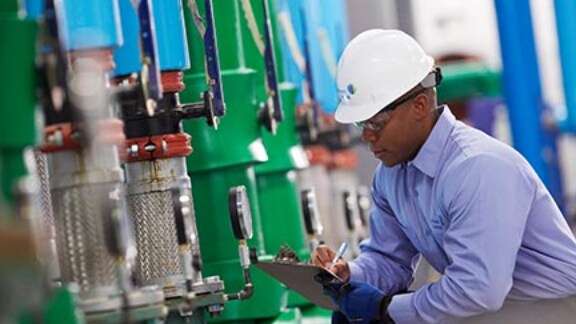 A supervisor taking the readings on the floor of a manufacturing unit