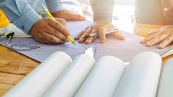 Close up of hands of two architects working on the floor plan design