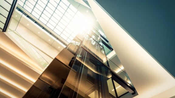 Sunlight peeking through the glass windows of a modern glass building