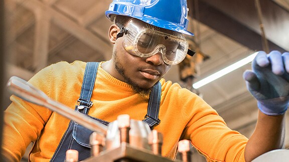 A person wearing a hard hat and goggles