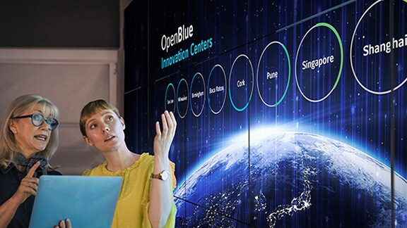 Two women discussing a presentation on OpenBlue Innovation Centers