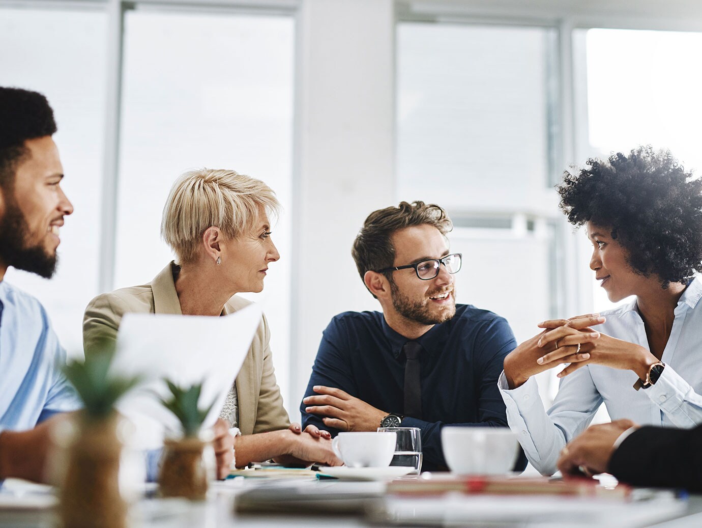 Employees having a discussion over coffee in a meeting room
