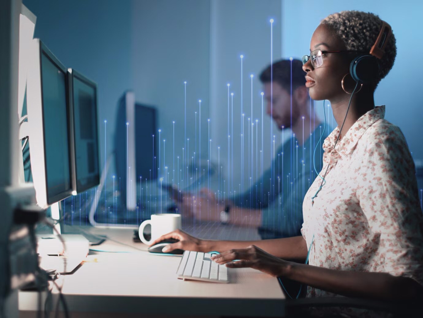Man and woman working on desktops in office, overlaid with a graphic of transmission nodes