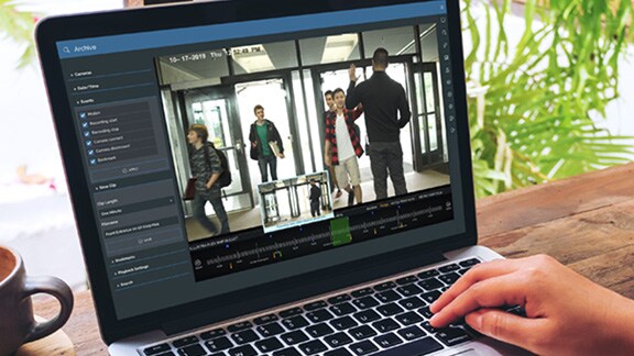Man working on a desktop displaying CCTV footage