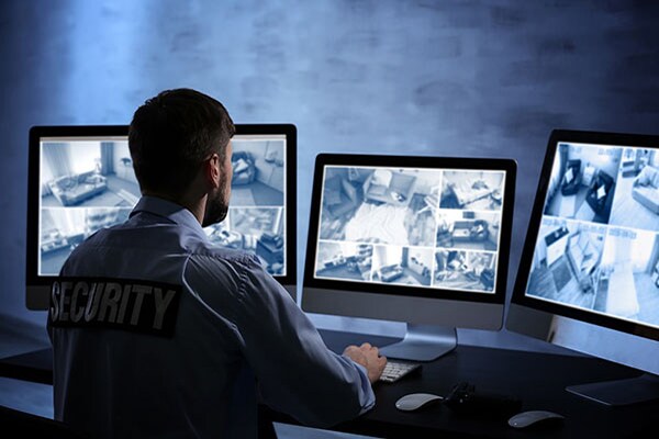 A man watching the cctvs closely in the video surveillance control room